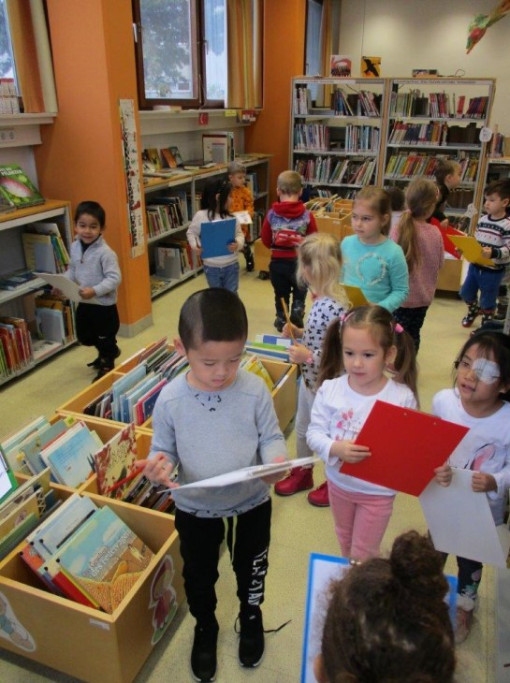 Kinder erfüllen eine Aufgabe in in einer Bücherrei