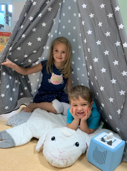 Zwei Kinder liegen in einem Zelt 