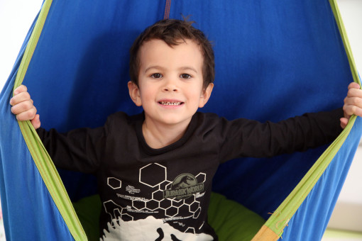 Ein Junge posiert amüsiert in einem Zelt 