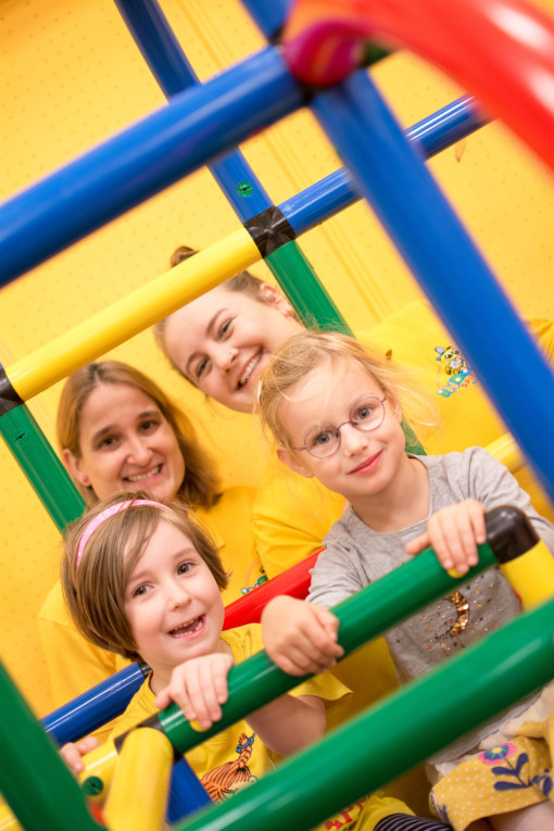 Zwei Mädchen auf einem Klettergerüst, hinter ihnen zwei Betreuerinnen